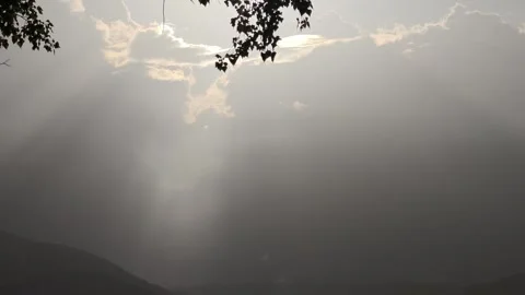 Sun shining through clouds over lake and trees Stock-Footage 310310354