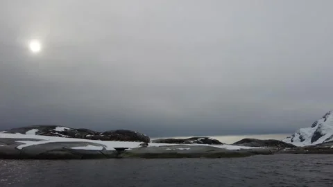 Sun Shining Through Clouds Over Rocky Antarctic Coastline Stock Footage 340021382