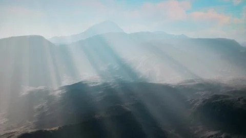 Sun shining through clouds over mountains イラスト素材