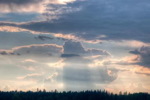 Sun shining through clouds over a wheat field Stock Photos