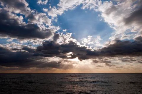 Sun shining through clouds Stock Photos