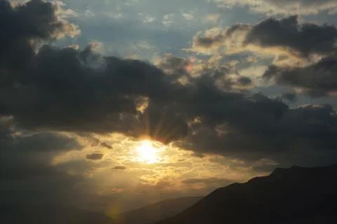 Sun shining through clouds Stock Photos