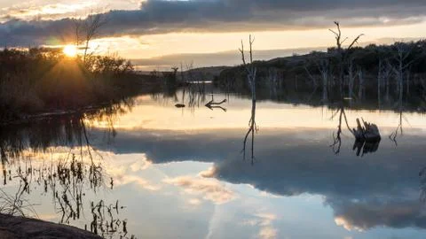 Sun Shining Through the Clouds Reflecting On Large Lake Stock Photos