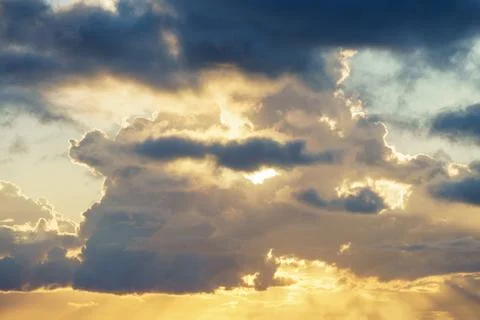 The sun is shining through the clouds in the sky during sunset Stock Photos