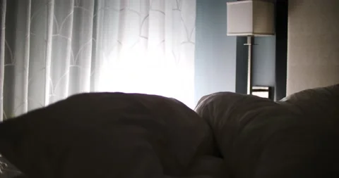 Sun shining through curtains pillows being thrown at bed early morning rising Video stock 213383877