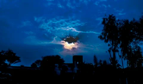Sun shining through dark clouds Stock Photos
