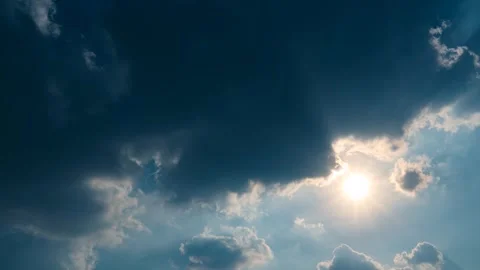 The sun shining through dramatic clouds and blue sky background Stock Footage 303894327