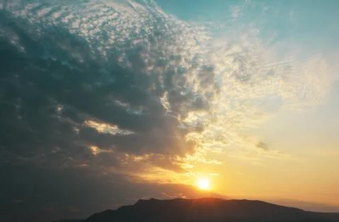 Sun shining through dramatic cloudscape Stock Photos