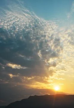 Sun shining through dramatic cloudscape Stock Photos