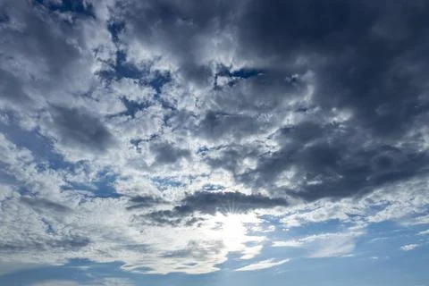 Sun shining through dramatic cloudscape filling sky Stock Photos