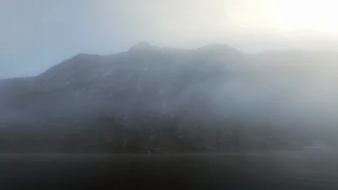 Sun shining through eerie mist on Bavarian lake in winter Stock Footage 120986917