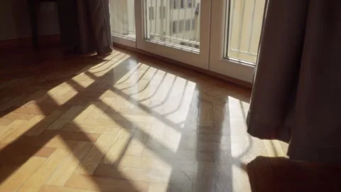 Sun shining through glass window creating shadows on parquet floor in apartment Stock Footage 308668085
