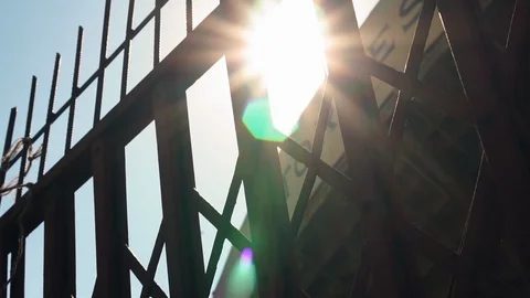 Sun shining through a high metal fence Stock Footage 129397001