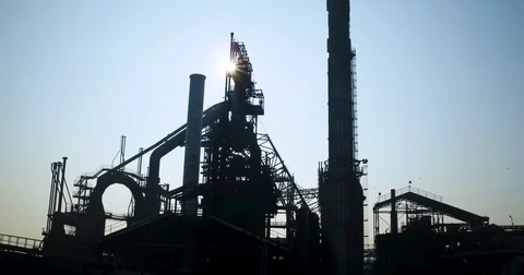 Sun shining through the huge factory tower and chimneys at an old steel factory Stock Footage 81534468