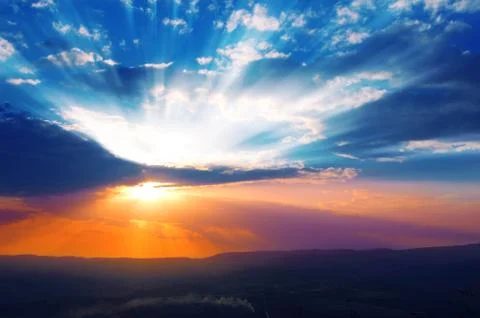 Sun shining through the low clouds of twilight Stock Photos