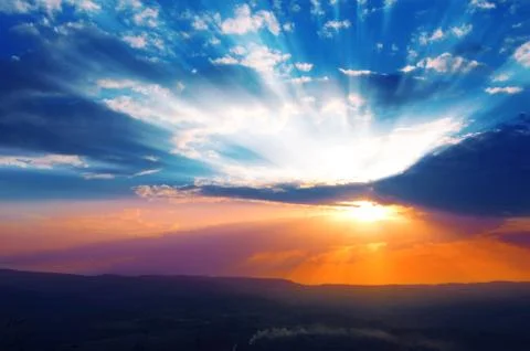 Sun shining through the low clouds of twilight Stock Photos