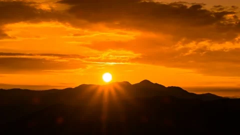 Sun shining through the mountain ridge. Time lapse. 库存影片 145742740