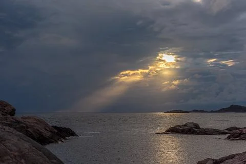 Sun shining through an opening in an otehrwise dense cloud layer. Sun shin... Stock Photos