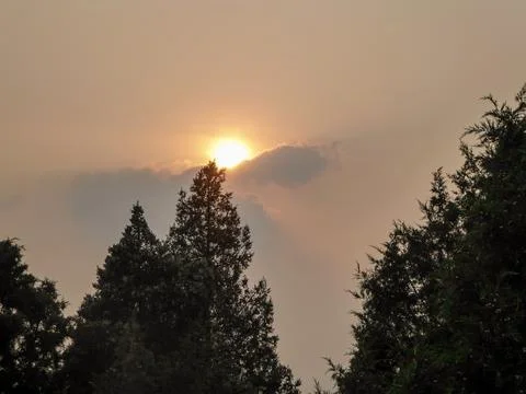 Sun shining through a thick cloud of smog above the Forbidden City, Beijing.. Stock Photos