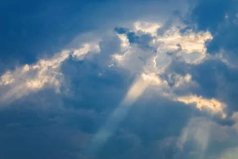 Sun shining through thick evening clouds. Stock Photos