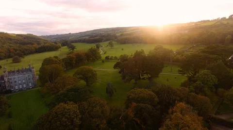 Sun shining through trees beside Castle at golden hour Autumn in Ireland Fotos Stock