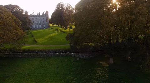 Sun shining through trees beside Castle at golden hour Autumn in Ireland Stock Photos
