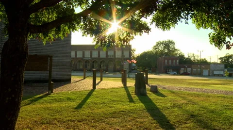 Sun shining through trees in small town Stock Footage 54638016