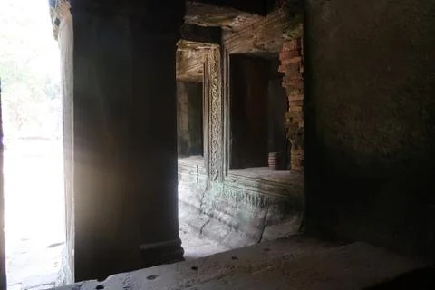 Sun shining through a window at stone pillar with ancient murals in famous Stock Photos