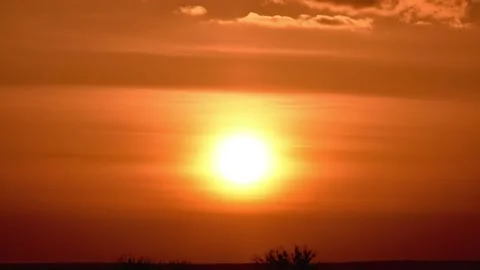 Sun sinks to horizon. Evening orange sky. Clouds quickly swim around sky. Stock Footage 197327680