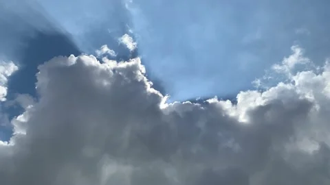Sun skimming top of cloud with crepuscular rays - time lapse Stock Footage 165431453