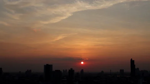 The sun slowly descends as warm evening light spreads across Bangkok city Видео 329374994