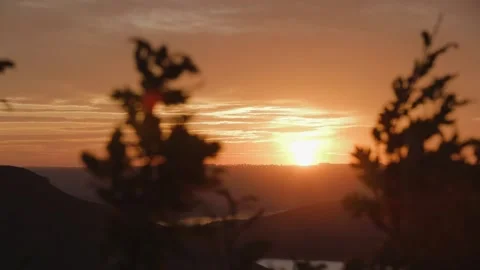 Sun slowly going down behind silhouette mountain ridge, beautiful orange sunset Stock Footage 148963666