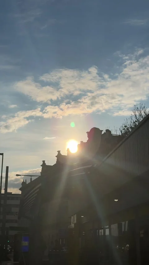Sun slowly tracking behind an urban architecture building, generating powerful Stock Footage 333299146