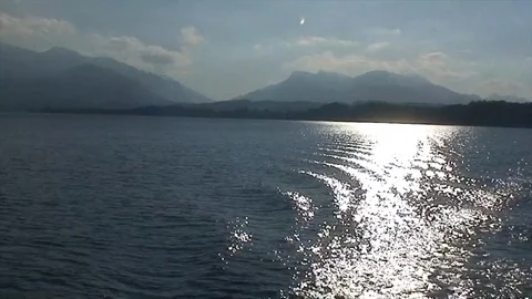 Sun sparkling in ferry's wake on an alpine lake Video stock 86091208