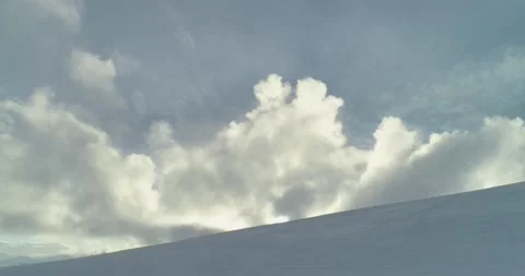 Sun streaming through clouds over winter snowy landscape arial shot Stock Footage 152785605