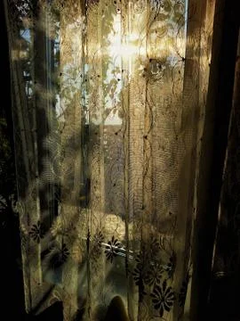 Sun at sunset light through the thin curtains on the window Stock Photos