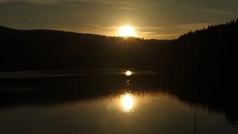 The sun at sunset over the lake in the mountains gradually disappears Stock Footage 247923068
