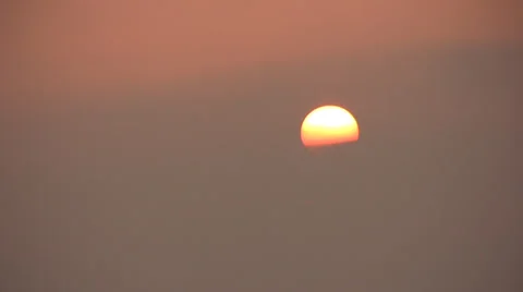 Sun at sunset partly obscured behind a band of cloud 스톡 동영상 36100752