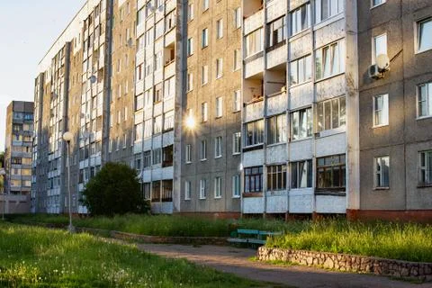 The sun at sunset reflected in the windows of a tall house Stock Photos