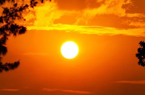  Sun at sunset Sun and cloud in sky with a bright orange glow at sunset Co... Stock Photos