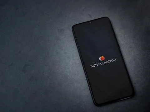 Sun Surveyor app launch screen on smartphone on dark marble stone background Stock Photos