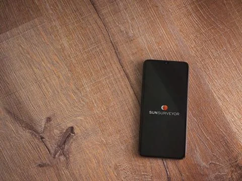 Sun Surveyor app launch screen on smartphone on wooden background Stock Photos