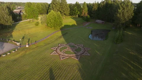 Sun Symbol Made of Stone on Grass - Drone Orbit Stock Footage 313623740