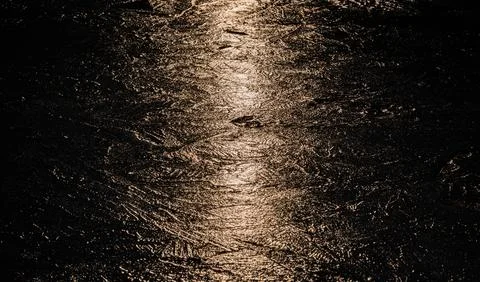 Sun on the texture of ice of a winter lake in a dark key Foto stock