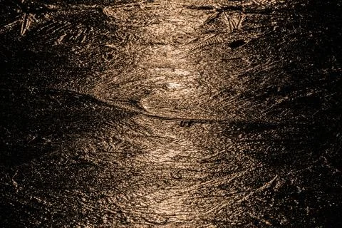 Sun on the texture of ice of a winter lake in a dark key Foto stock