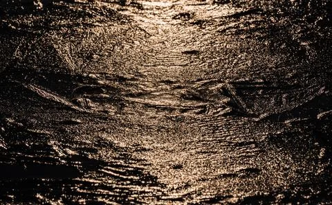 Sun on the texture of ice of a winter lake in a dark key Foto stock