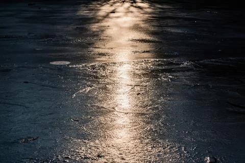 Sun on the texture of ice of a winter lake in a dark key Foto stock