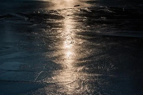 Sun on the texture of ice of a winter lake in a dark key Foto stock