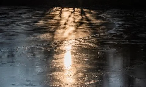 Sun on the texture of ice of a winter lake in a dark key Foto stock