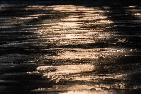 Sun on the texture of ice of a winter lake in a dark key Foto stock